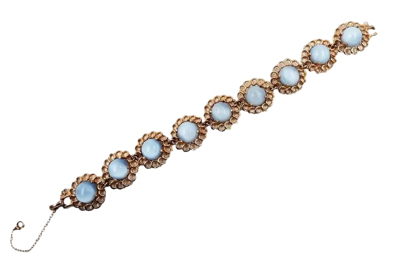 Vintage 1950s Reja Goldtone Faux-Blue Moonstone Bracelet: 1950s goldtone cabochon faux-blue moonstone rhinestone bracelet with fold over clasp and security chain. Unmarked Reja. The matching earrings, now sold, were marked. Measures: 8 inches long by 0.75