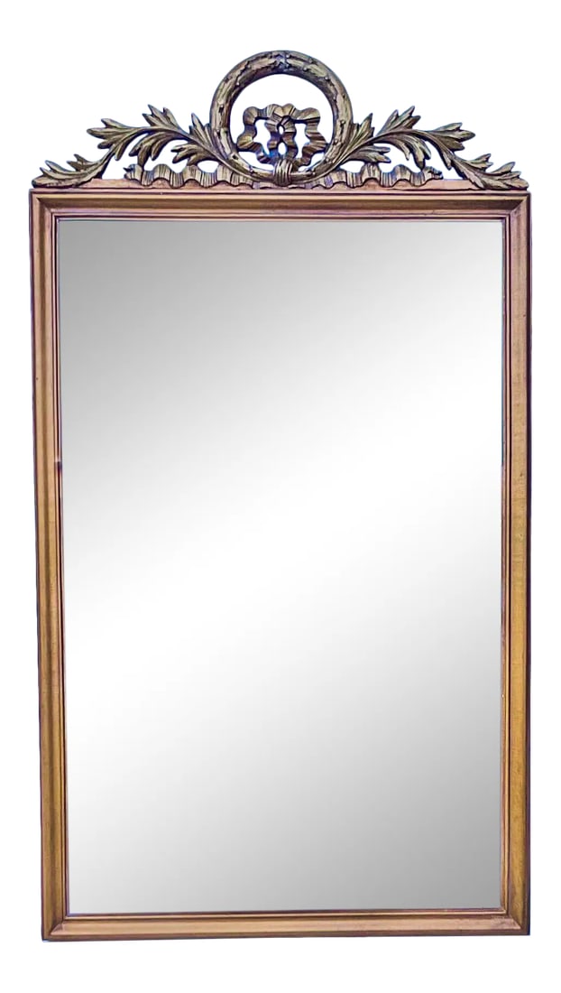 1940s French Neo-Classical Style Carved Giltwood Mirror: This is a lovely French carved giltwood mirror. It is a nice size and contributing to it's beauty is it's simplicity. It has a carved laurel crown with both ribbon and leaf foliate at it's base.