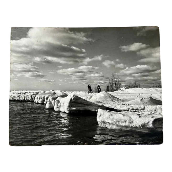 1950s Lake Michigan Large Black and White Mounted Photograph: A gorgeous 1950s black/white photo of Lake Michigan in the winter. Four visitors, clearly cold and underdressed, take in the spectacular beauty of the Muskegon South Pierhead Lighthouse and Lake