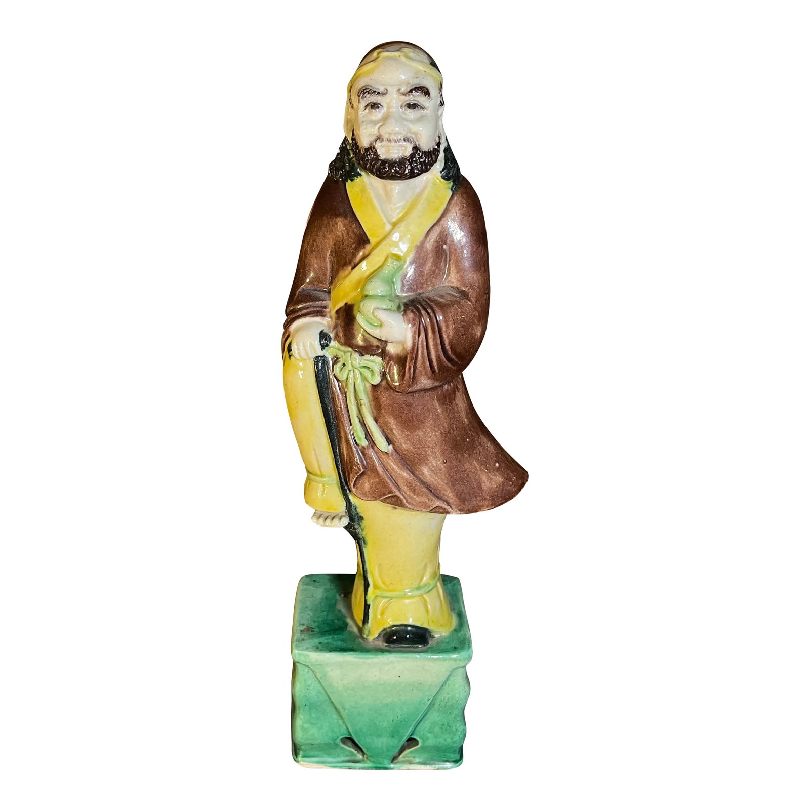 Late 19th Century Chinese Sancai Glazed Porcelain Figure of an Immortal: Beautiful glazed pottery and figure detail. Earthy tones of brown, green, and yellow. I especially like his raised foot on pedestal and little toes. Marked China to underside in red. Condition: