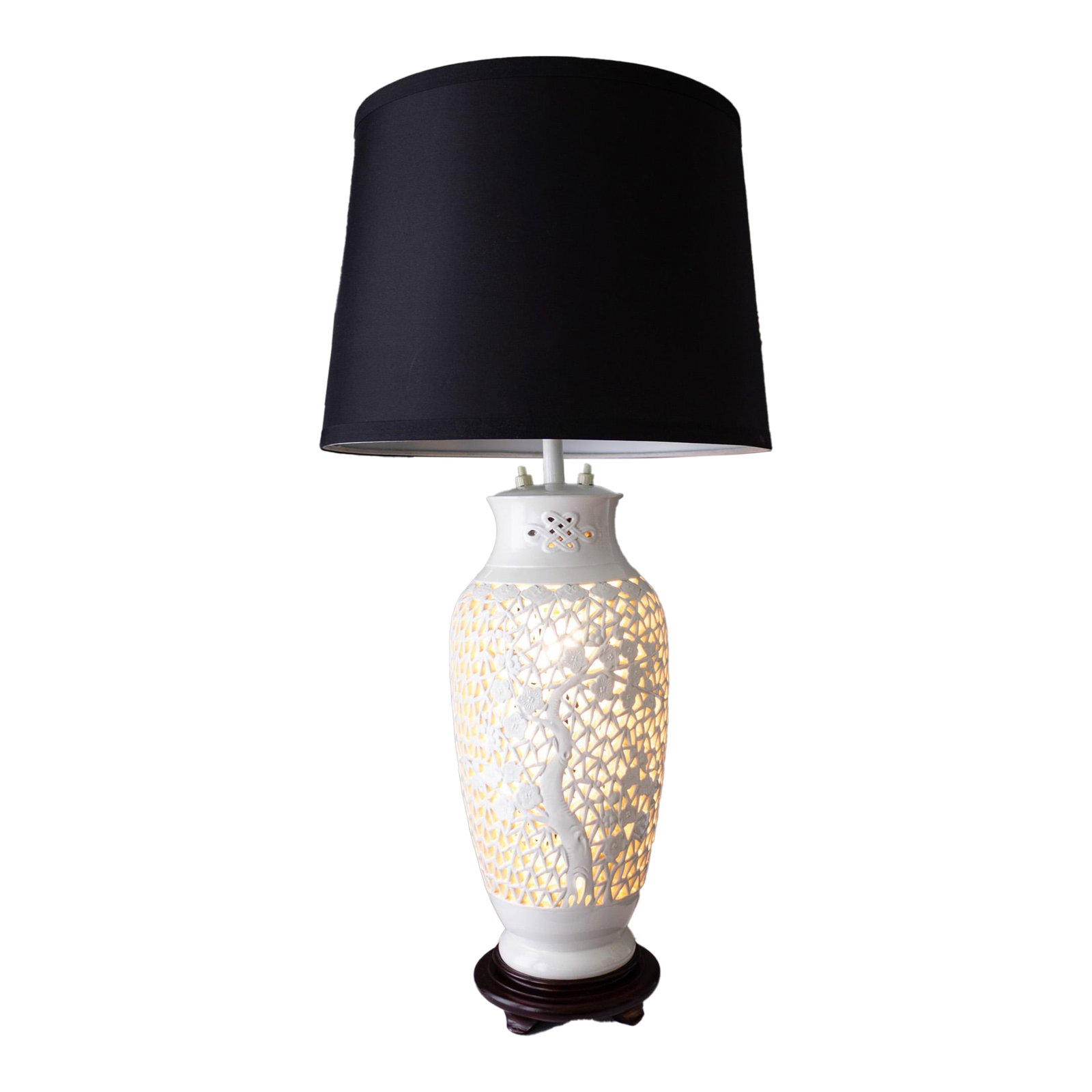 Blanc De Chine Pierced Chinoiserie Lamp With Prunus Tree Plum Blossoms: A white reticulated chinoiserie blanc de chine porcelain lamp featuring a prunus tree and plum blossoms, sitting on a round rosewood footed pedestal. In addition to traditional lighting, this lamp