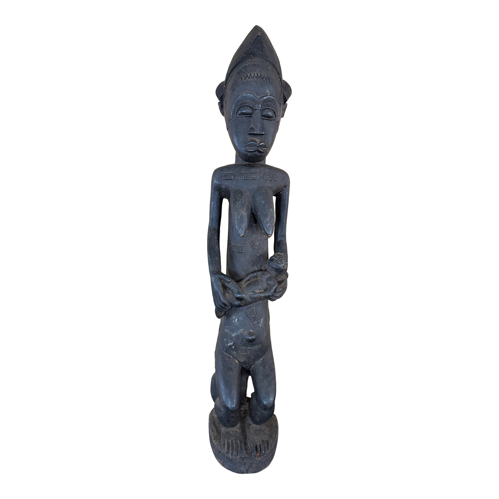 Baule Female Maternity Figure. 20th Century: Baule female maternity figure sitting on a stool and holding a baby from the 20th century. This is made of wood and black in color. It shows signs of aging due to cracks on the figure . It measures 46
