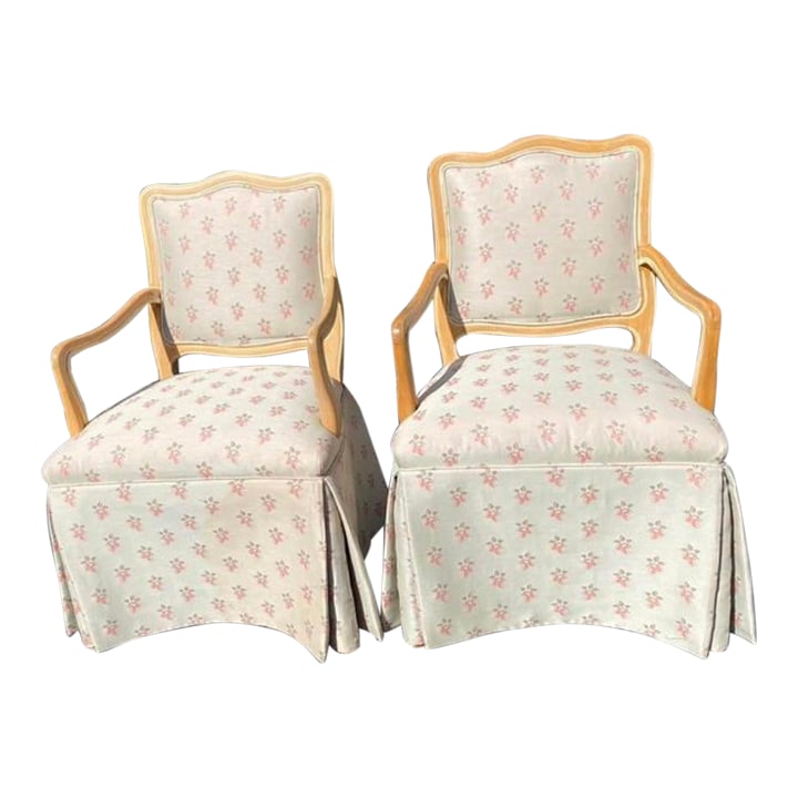 Pair of Mid Century French Provincial Skirted Dining Chairs in Floral Upholstery: Quick Hits Pair of French Provincial style skirted side chairs or dining chairs Mid-20th century American craftsmanship Ivory upholstery with soft pink floral pattern Curved backs with tailored