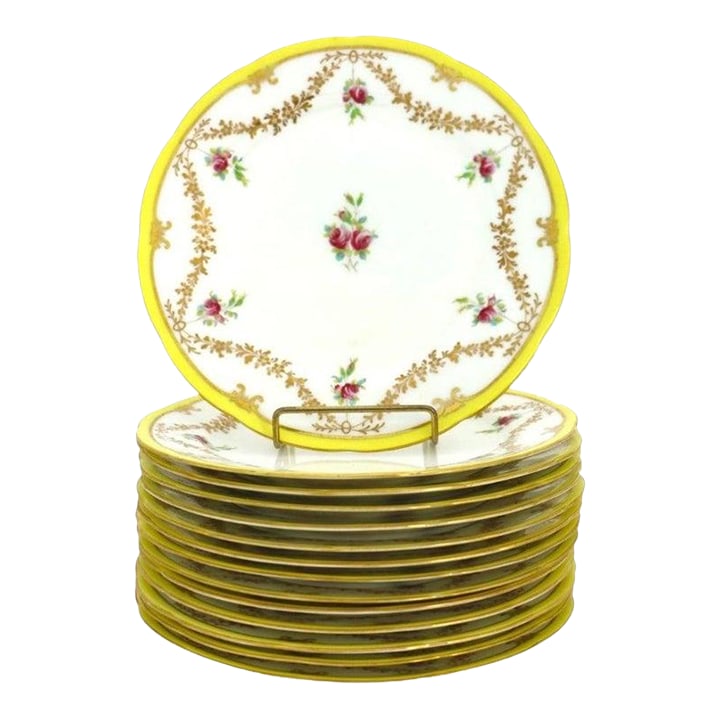 14 English Cauldon Ware Floral & Gilt Porcelain Dinner Plates C1920: This exquisite set presents fourteen antique English Cauldon Ware porcelain dinner plates, dating to approximately 1920. Each plate is meticulously crafted from fine, white porcelain, showcasing the r