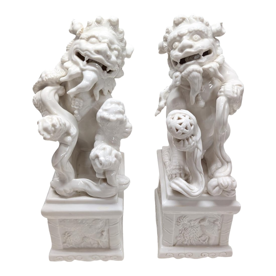 Pair of Vintage Chinese Porcelain Blanc De Chine Foo Dog Statues.: Wonderful matching pair of Blanc de Chine porcelain Buddhist lions standing on a pedestal. Foo dogs, as they are commonly called in the West, actually depict lions that usually stand guard in front