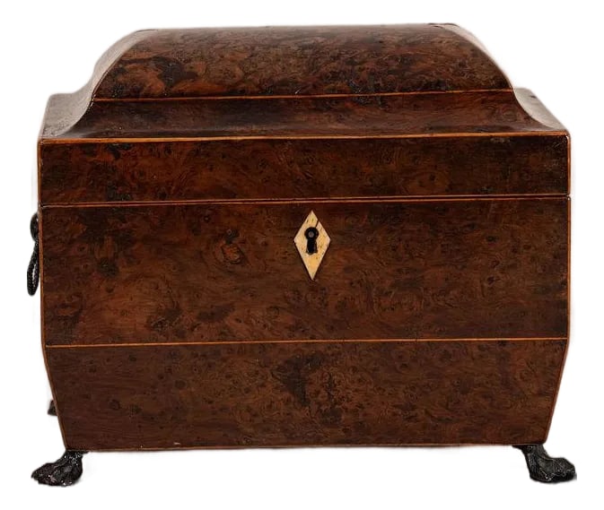 Regency Burl Yew Tea Caddy (C. 1820): Regency burl yew tea caddy featuring figured veneers, inlaid stringing, and a hinged lid. A finely crafted early 19th-century box ideal for display or collection. Condition: Alterations: Original Cond