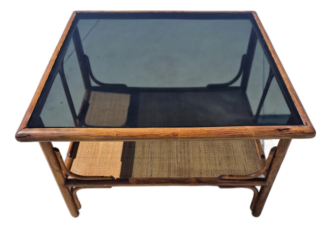 Mid-Century Italian-Style Bamboo Coffee Table With Smoked Glass Top and a Lower Rattan Shelf.: This vintage 1970s style mid-century modern coffee table features an organic, boilerplate bohemian design built from thick tortoise-shell-toned bamboo poles and wrapped rattan bindings. Its prominent