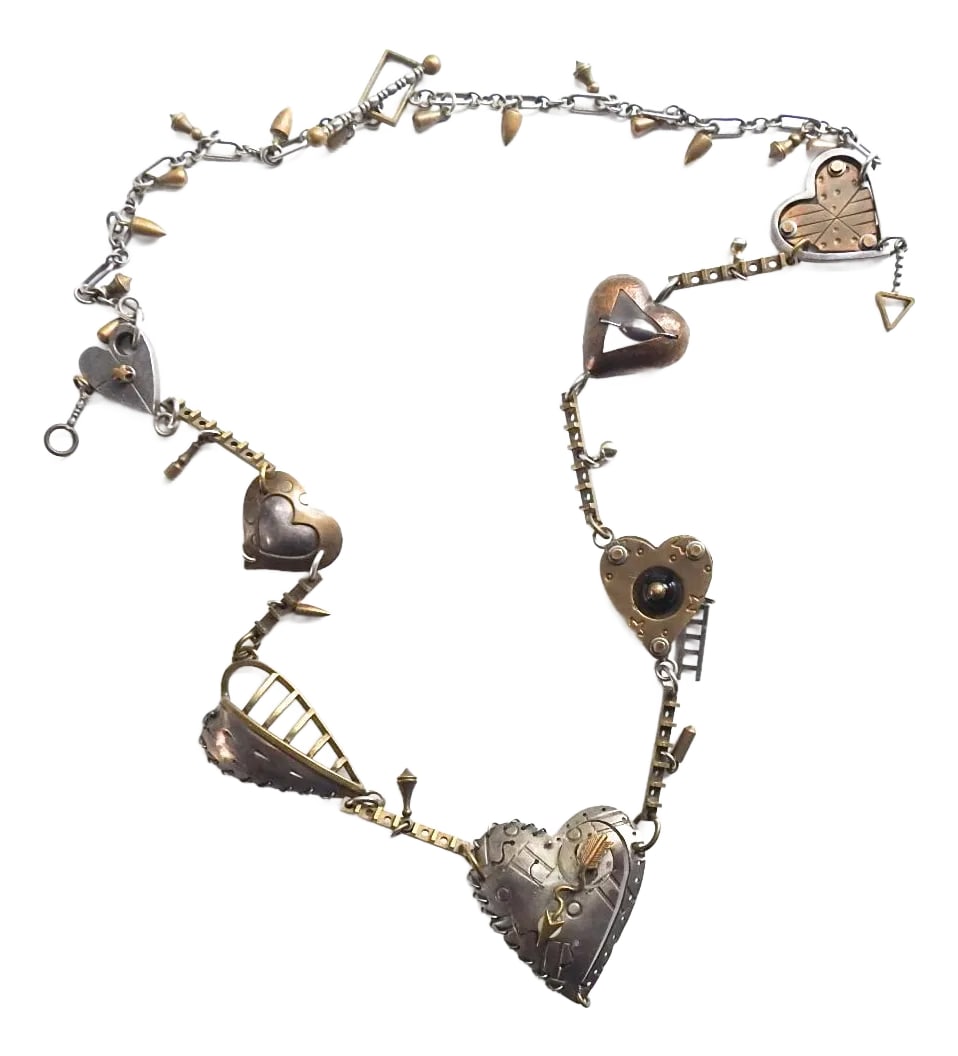 Vintage Thomas Mann Sterling and Brass Heart Charm Necklace: Vintage sterling silver and brass Thomas Mann heart charm necklace. Intricate detailed techno romantic components. Main heart is 1.5" x 1.5" excluding small drop, overall dark patina. Condition: