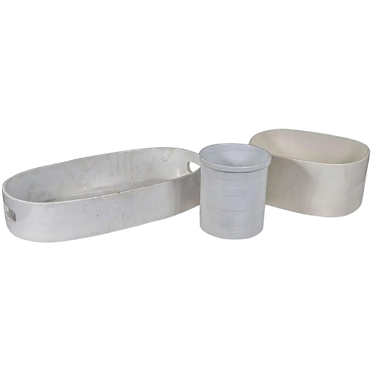 Three Ivory-Glazed Pottery Articles: Two oval deep trays, one with pierced handles and an English cylindrical relief-banded jar, marked "CTM Trade Mark, England 36740" Smaller potteries measure 3.5"x 6" and 5 x 10." Prov. The Collection