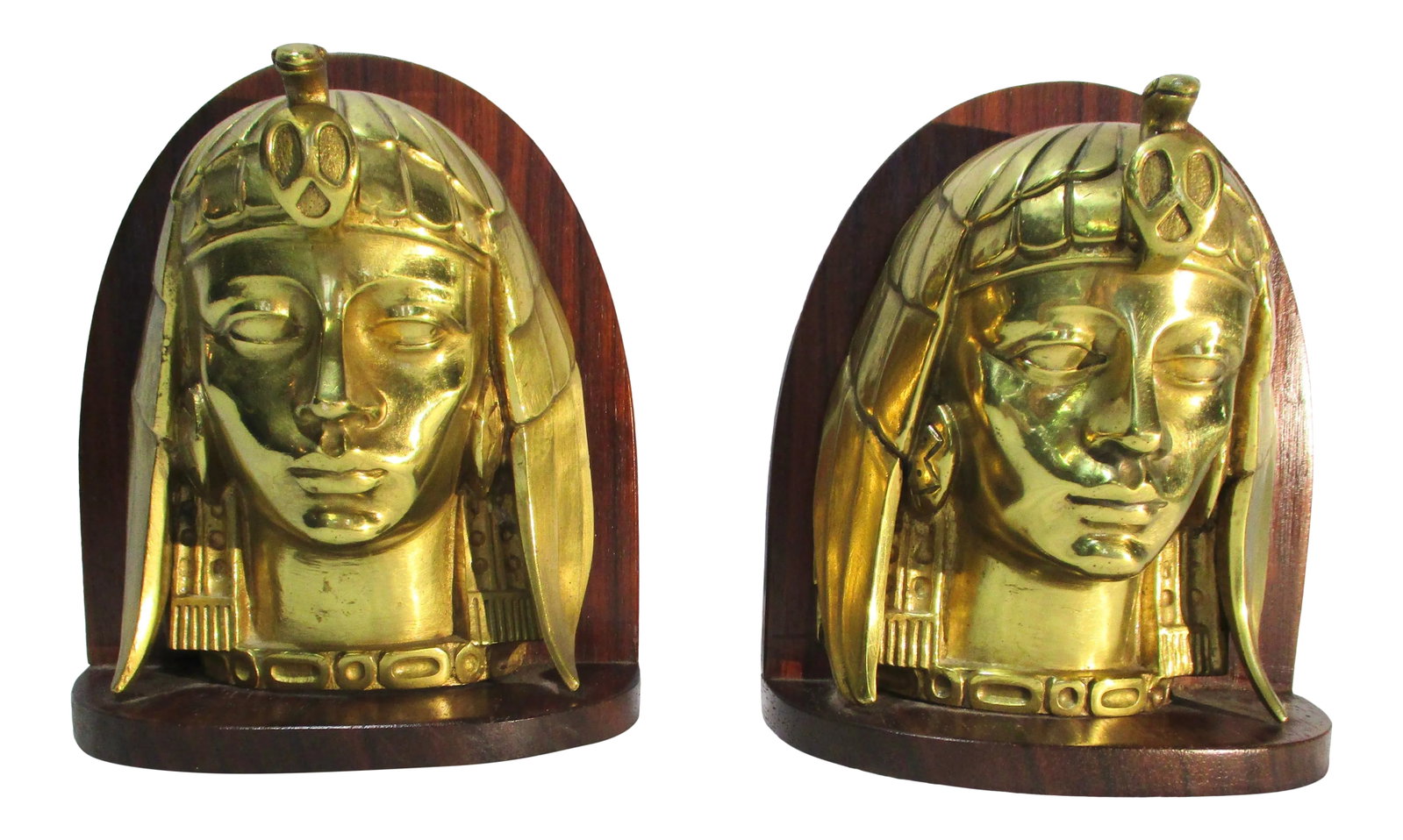 Art Deco Egyptian Revival Brass Bookends - a Pair: Art Deco Egyptian revival glamor Female heads on Mahogony panel backs and bases. Heavily weighted lacquered brass cast cobra crowned faces on arched backplates. Hollywood glamor from the '40s, with a 
