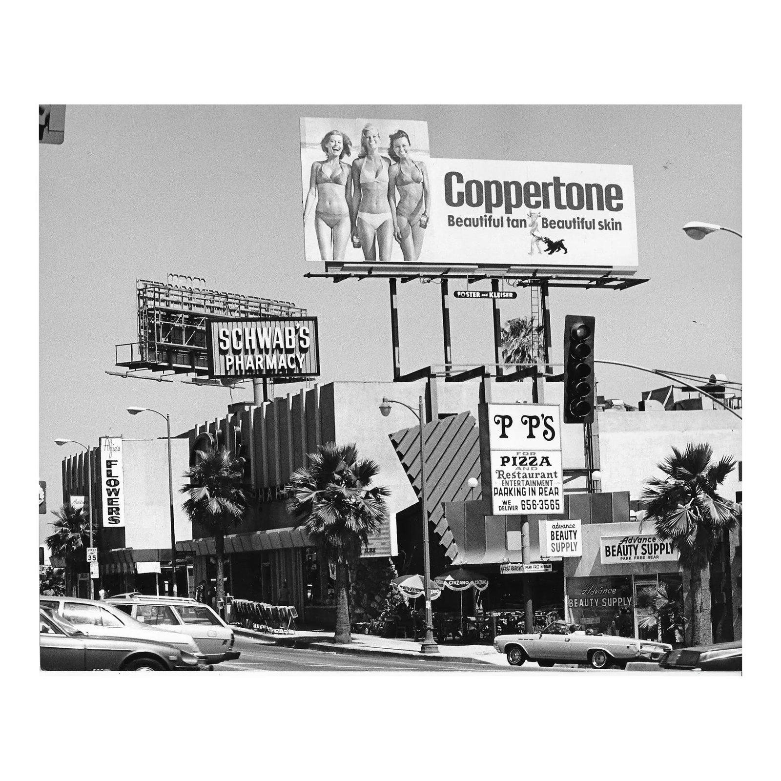 1978 Schwabs Drugstore Hollywood Photograph: 1978 Los Angeles b&w photo of Sunset Boulevard by Don Coleman Ware (1921-2006). Schwab's Pharmacy is in the background and a Coppertone billboard stands over the street. Title and Ware's stamp on