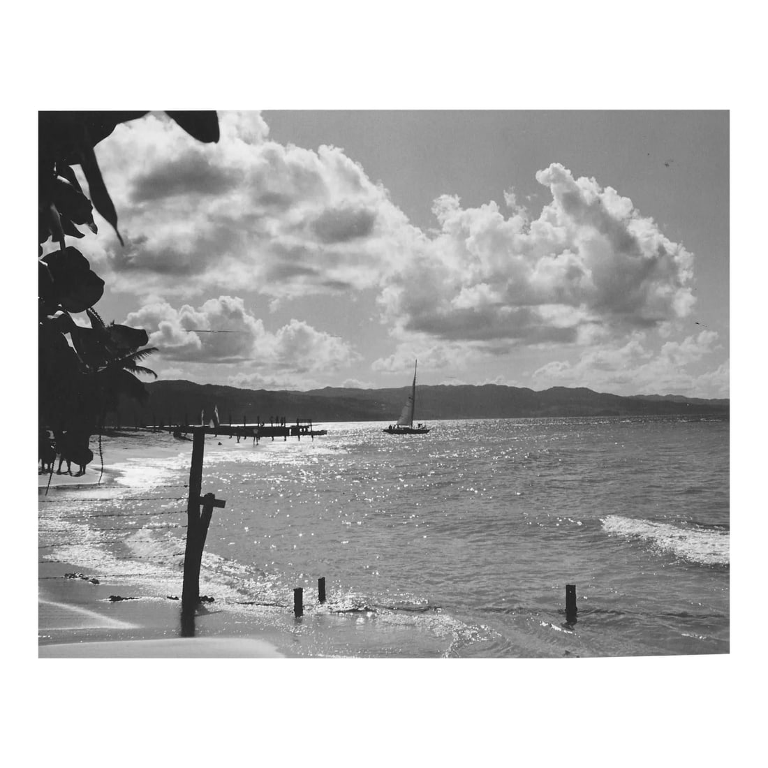 1966 Montego Bay Jamaica Photograph by Don Ware: 1966 black and white photo by Don Ware (1921-2006) of a Jamaican beach and sail boat. Titled and dated; bearing Ware's studio stamp on the back. Condition: Alterations: Original Condition Unaltered