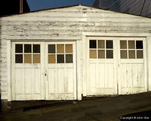 Contemporary Night Photograph "Double Garage" by John Vias: Note from the artist, John Vias: "If you look closely, you can see the repeating circular and cross-hatch patterns in the windows of this old garage. I captured this scene at night in San Francisco." 