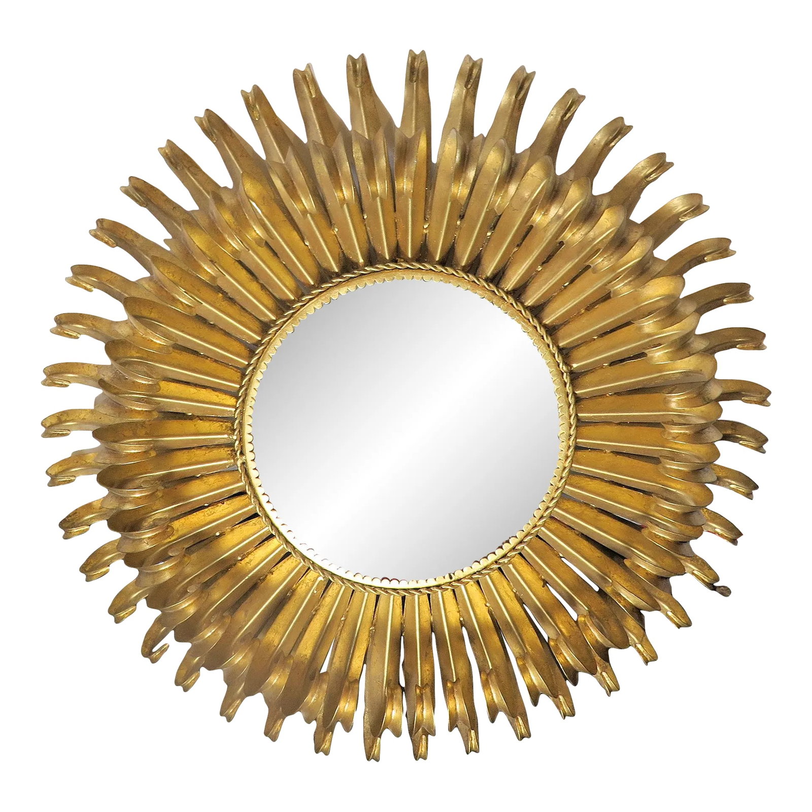 1950's Style Gold Leaf Heavy Wrought Iron Sunburst Mirror: This heavy brass wrought iron Sunburst mirror is in the manner of the Hollywood Regency style. What makes it unique from so many other mirrors of the period is the way that the "rays of the sun"