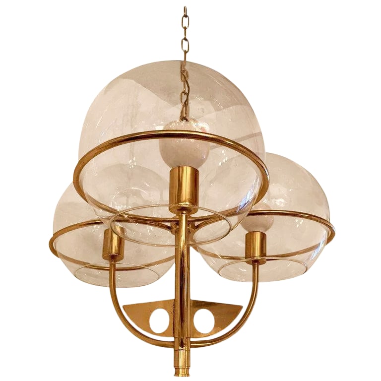 1970s Vintage Italian High Style Brass Pendant: A 1970s swooping golden brass Italian chandelier with three large glass globe shades. Newly rewired. Condition: Alterations: Restored Imperfections: Some Imperfections Condition Notes: Excellent Wear 