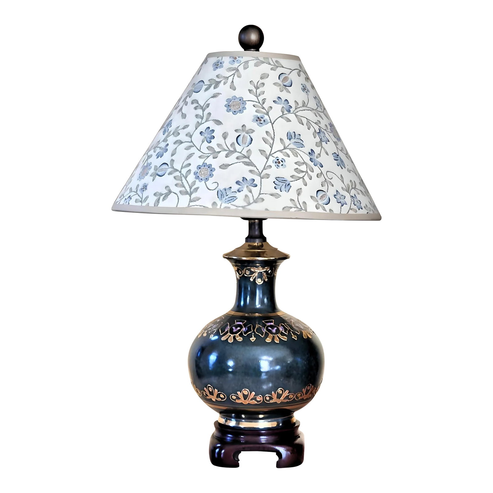 1990s Small Dark Green Porcelain Table Lamp Accented With Gold and Lilac Purple: A lovely porcelain table lamp in classic dark green, accented with gold and lilac purple English motifs, with a beautiful floral lamp shade, sitting on a brown base. Features: Floral hard backed fabri
