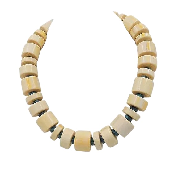 Vintage Signed Monet Beaded Ad Piece Necklace, 1982: Faux-ivory beads with turquoise colored spacer beads necklace with a spring ring clasp. Marked with a Monet hang tag. Measures: 7 inches long by 5 1/2 inches wide. Center; 3/4 inches long. Excellent c