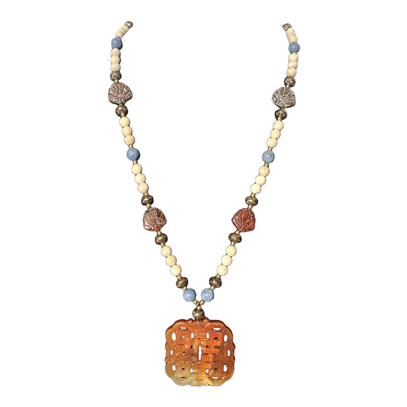 Early 20th Century Carved Jadite Beaded Necklace: This carved Jadite beaded necklace features a stunning orange Jadeite stone as the main focal point. The pendant style necklace is handcrafted and artfully designed, making it a unique and