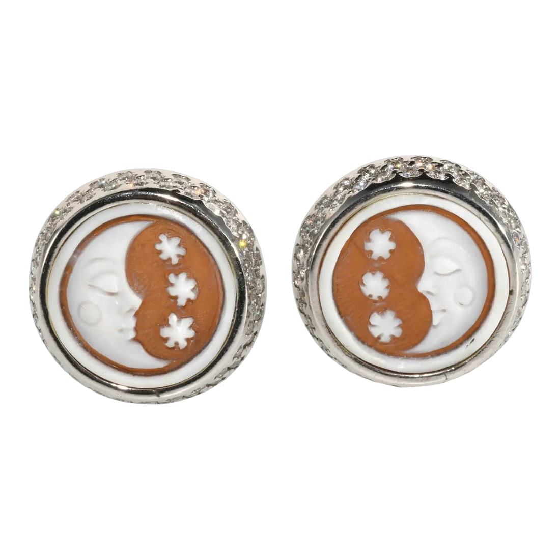Sterling Silver Pierced Earrings Moon & Stars Carved Shell, A Pair: Pierced earrings with omega backs made of sterling silver set with carved shell in cameo style with moon and stars motif. Clear stones around the edges appear to be cubic zirconia (CZ). Marked 925.