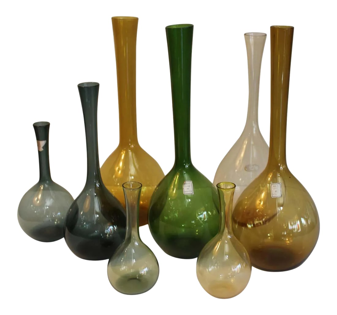 1960s Swedish Glass Vases Designed by Arthur Percy - Set of 8: Eight glass bottles made in Sweden by Arthur Percy in green, blue, amber. Sizes range from 5.25" to 11.75" high. Four of the glass bottles have labels. Condition: Alterations: Original Condition