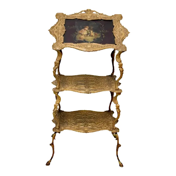 Early 20th Century Victorian Style Three Tier Bronze Music Stand: Victorian style three tier metal stand having central paint decoration depicting girl and boy with sheep. Metal frame resting on paw feet. Used condition, wear, worn, break to metal. Shipping & Logist