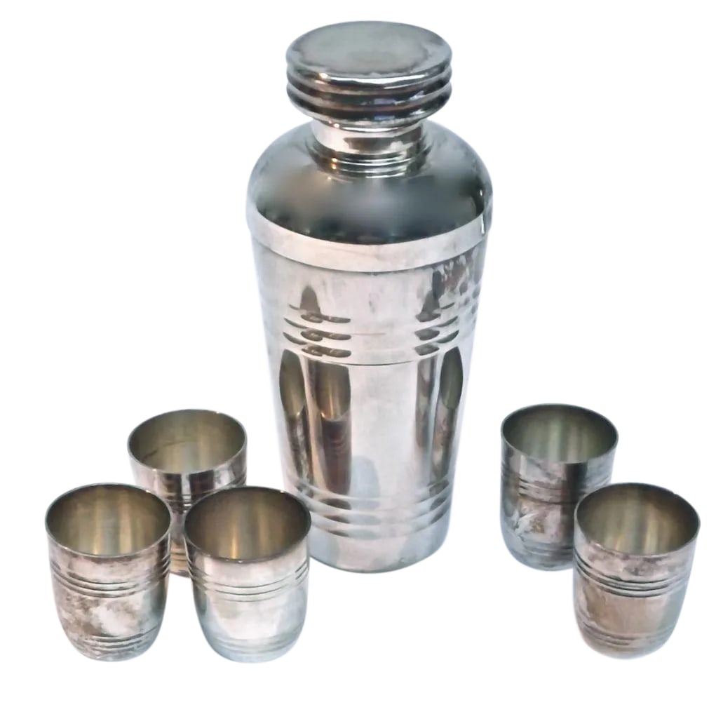 Art Deco Silver Cocktail Shaker & Cups - Set of 6: This silverplated, Art Deco cocktail shaker set comes with 5 cups and the shaker includes a lid, strainer, and mixer. The set was made between 1910-1950 and features a Machine Age style, streamlined