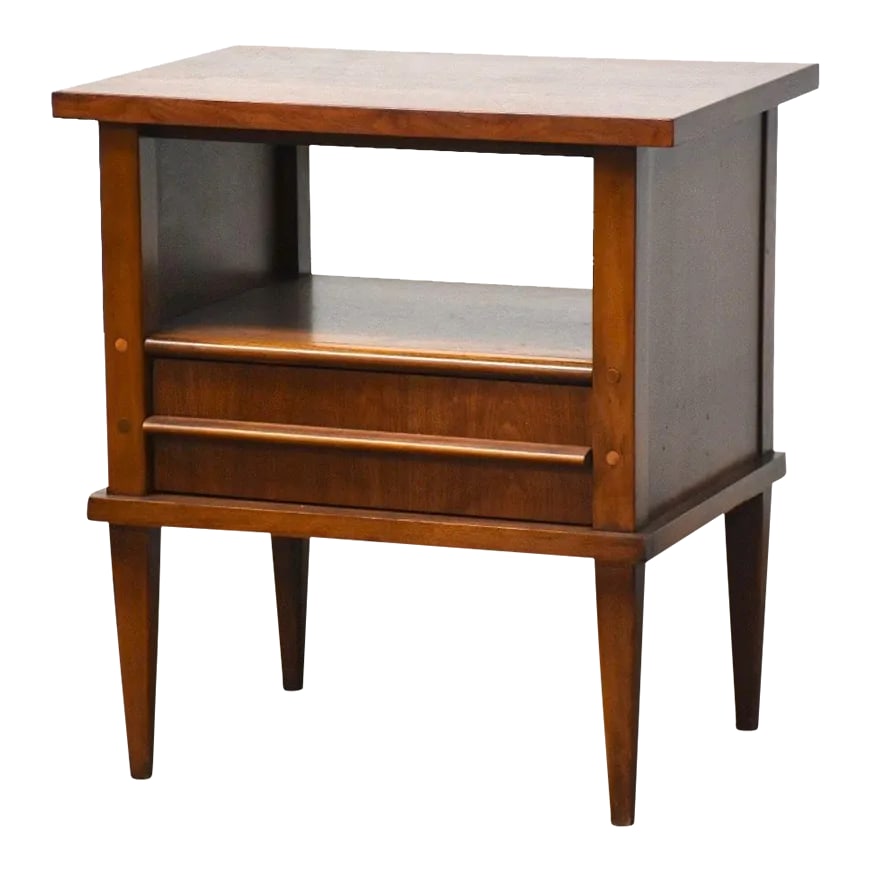 Walnut Nightstand by Kent Coffey Simplicite: A mid century modern walnut nightstand with a single drawer, sculpted drawer pull and shelf made by Kent Coffey Simplicite. 24" wide. 17" deep. 26" tall. Condition: Alterations: Restored