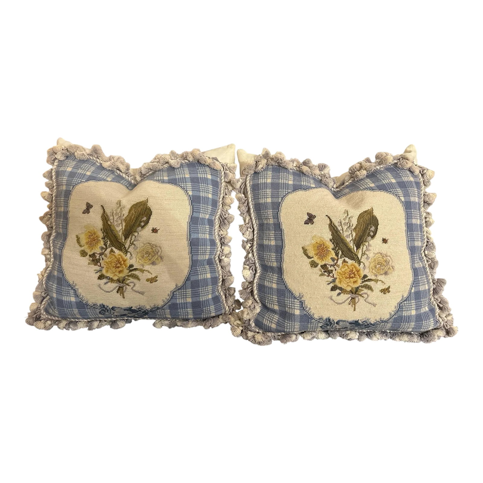 Pair of Vintage Needlepoint Pillows: Gorgeous alabaster white velveteen zippered base with a needlepoint front panel edged in tassel trim in steely blue and cream white. In front of that is a same blue and white twisted cording. Then