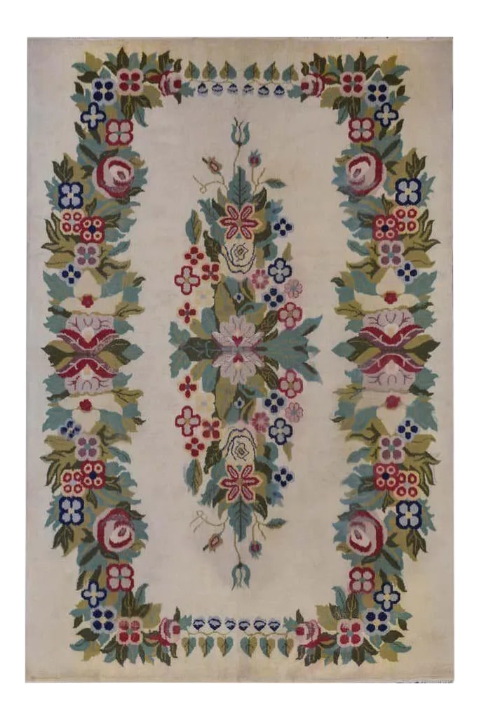 Vintage Chinese Style Rug: An unusual vintage Indian rug woven with a Chinese Art Deco style pattern containing bouquets of flowers woven in various shades of green, pink, cranberry, and light and dark indigo colored wool, surr