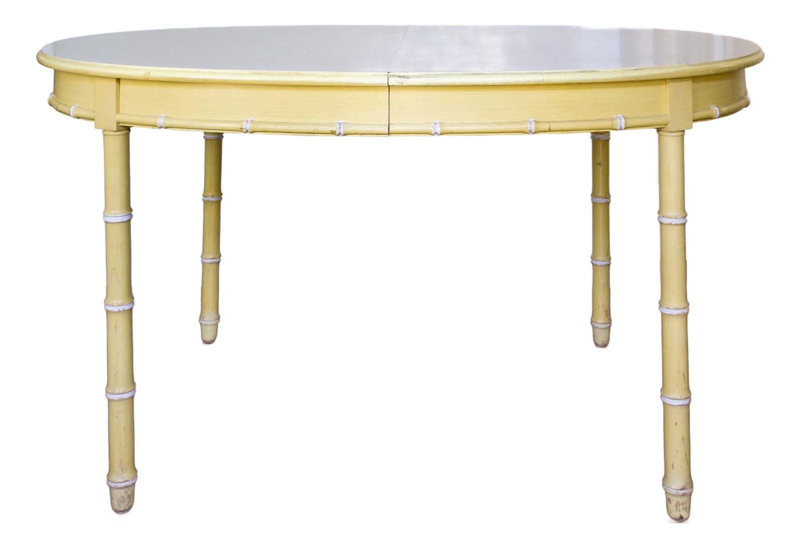 Thomasville Faux Bamboo Butter Yellow Oval Dining Table: This 20th-century Thomasville oval dining table features faux bamboo legs with a faux bamboo trim around the apron. It maintains its original butter-yellow paint and white Formica top, which features 