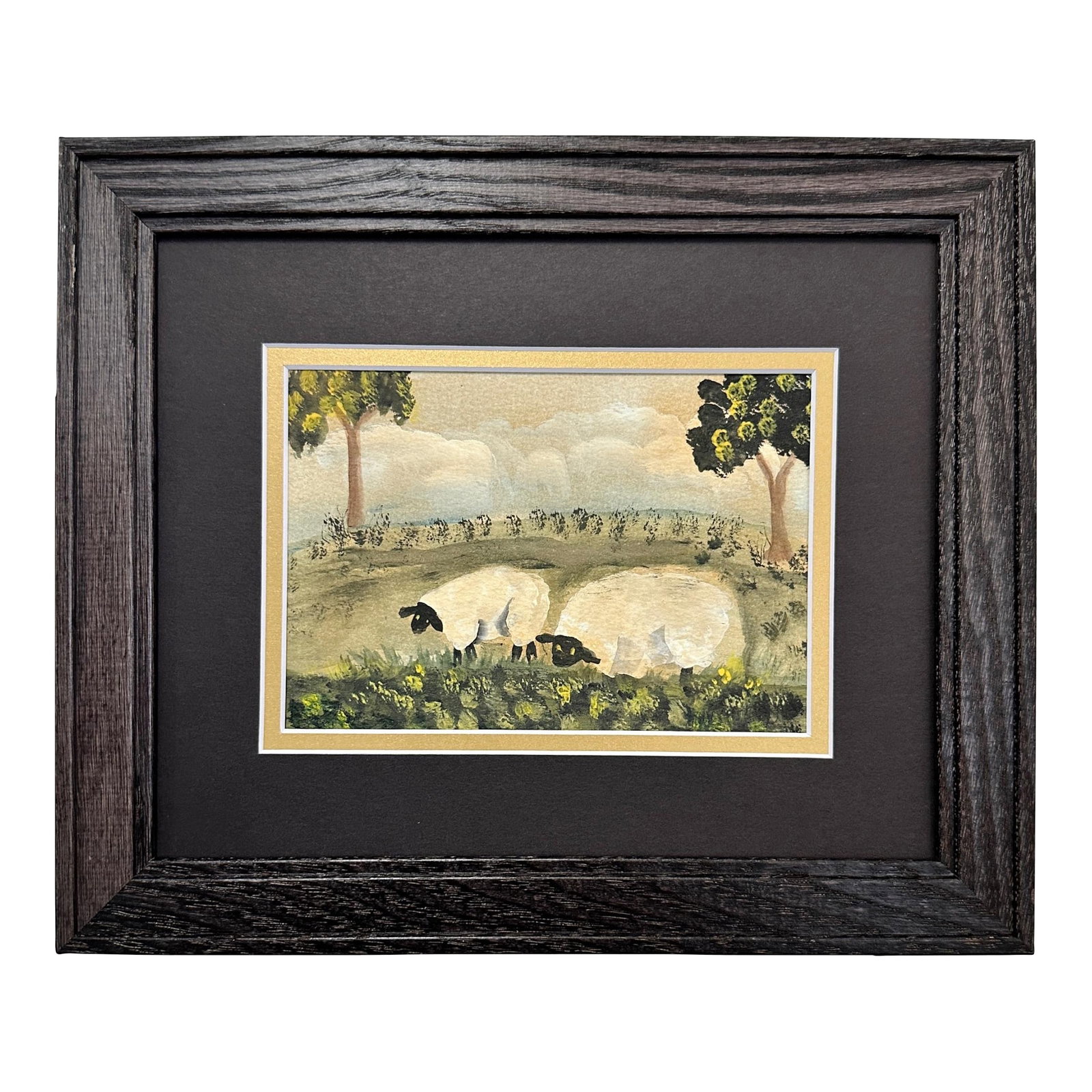 Folk Art Watercolor of Two Sheep: Folk art watercolor of a pastoral scene with grazing sheep under a cloudy ombre sky. Rendered in a primitive style with stylized trees and rolling hills, this unsigned piece was sourced on Route 1 in