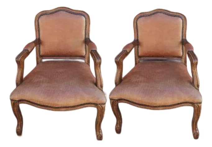 Classic Pair of Louis XV Style Armchairs: Step into a world of classic elegance with this magnificent pair of Louis XV style armchairs. Crafted with beautifully carved wooden frames and upholstered in rich, warm brown leather, these chairs