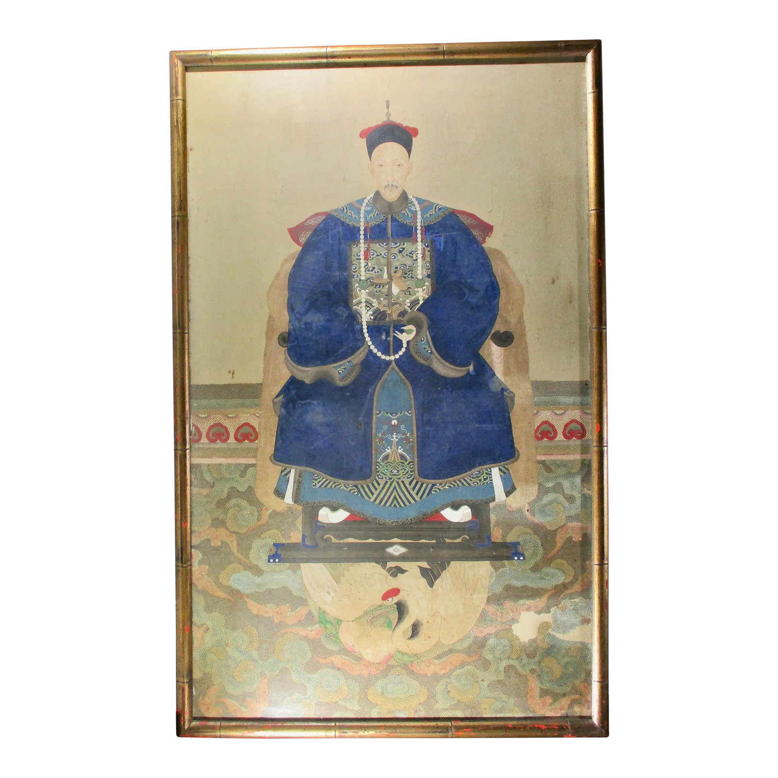 Antique Chinese Ancestor Portrait Painting, Framed: Traditional ancestor portrait. Hand-painted image Gauche on paper, of seated Mandarin senior with deep blue robes, a phoenix badge, and wearing a black hat with red fringe topped by a finial. Presente