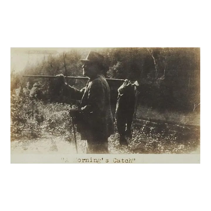 Vintage Fishing Photograph: Vintage silver gelatin photograph of man with fish. Titled in plate "A Mornings Catch", unsigned. Unframed, mounted on tan cardboard backing, photo size 6.25" x 4", corner bumps to backing.