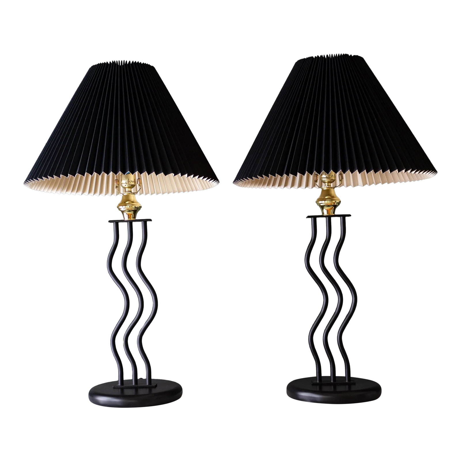 Black Wavy Memphis Style Squiggle Lamps | Set of Two: A pair of two vintage black, sculptural, Memphis-style squiggle table lamps feature a round base supporting three wavy tubes. Finished with black and cream pleated accordion lampshades, secured with