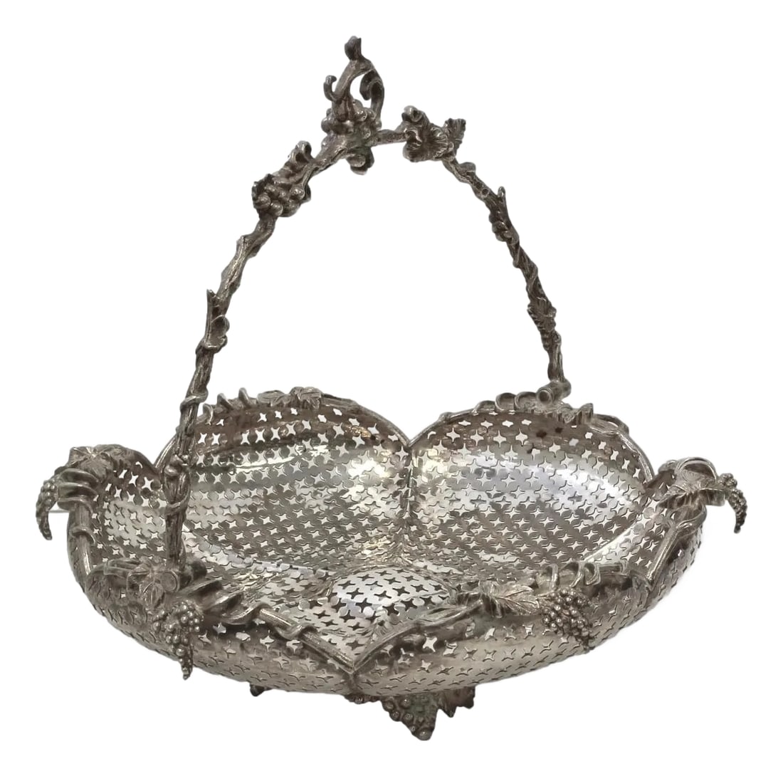 English Silver-Plate Pierced Basket: A beautifully detailed late Victorian silver-plated basket, likely intended as a grape or fruit basket, featuring intricate piercings, a scalloped rim, and a swing handle adorned with lush grapevine m