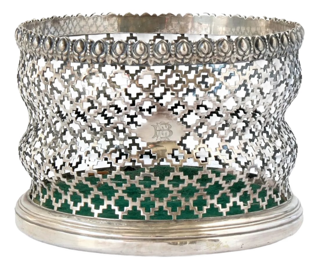Early 19th Century English Wine Coaster: Exquisite early 19th-century English wine coaster with intricate pierced latticework. The gently flared form allows light to play through the ornate design. A subtle monogram, likely a family crest,