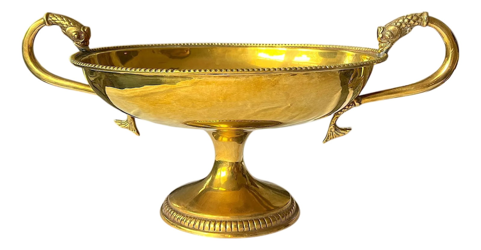 Large Vintage Solid Brass Dolphin Handle Compote Footed / Pedestal Bowl in the Style of Sherle Wagne: A Palm Beach Regency classic-this vintage solid brass compote features sculptural dolphin handles that add just the right touch of coastal whimsy to its neoclassical form. The beaded rim and pedestal