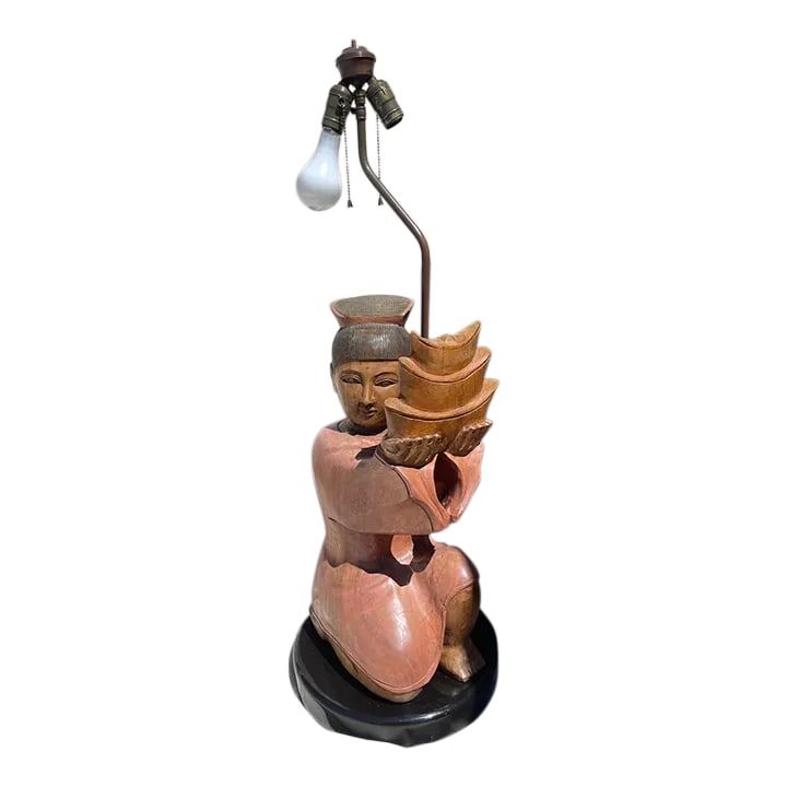 Vintage Hand Carved Asian/Indonesian Wood Figure Table Lamp: Vintage Hand Carved Solid Wood Figure Table Lamp in a peach color with tans and a black lacquered round base. Brass hardware that was painted and can easily be taken off. A black lamp shade would look