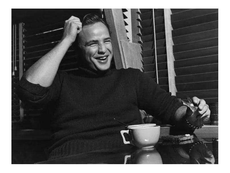 Marlon Brando at His Beverly Glen Home in Los Angeles 1953 (Photo by Sid Avery): Marlon Brando eating toast at his Beverly Glen home in Los Angeles, 1953. 11" x 14" silver gelatin fiber based print signed on verso by the photographer, Sid Avery. Edition #23 out of 70. Condition: I