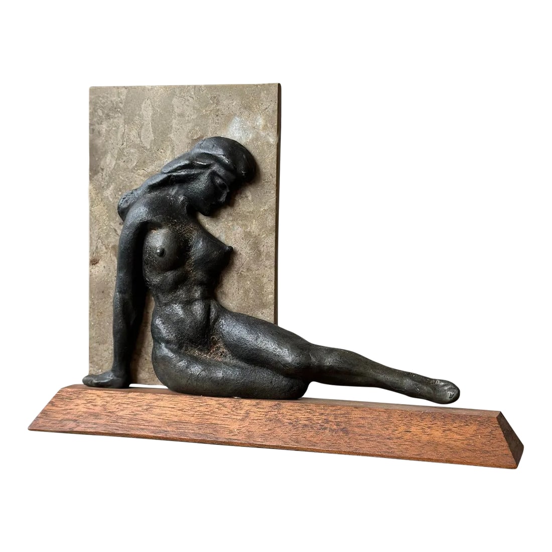 Vintage Reclining Cast Metal Nude Sculpture, Circa 1970: Vintage Reclining Cast Metal Nude Sculpture, Circa 1970. Cast reclining nude with a deep gunmetal patina, mounted atop an angular teak base. The stone back plate is a repurposed tile sample from