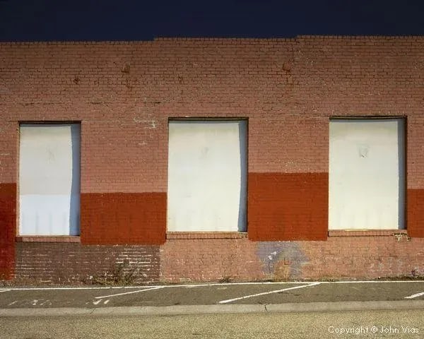Contemporary Night Photograph "Three Doors" by John Vias: Note from the artist, John Vias: "This is another in my series of abstracted building facades." This 8" x 10" archival color photograph is presented in a 20" x 16" archival white mat. Condition: Imper