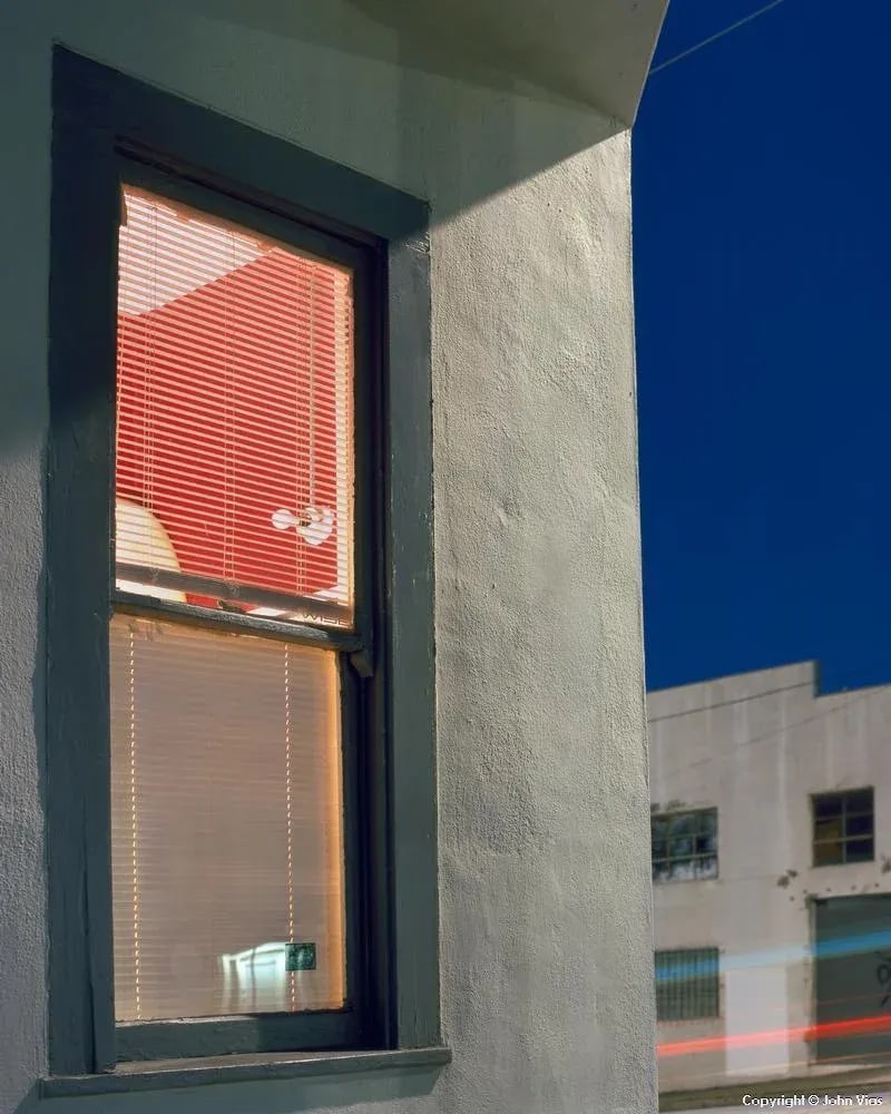 Contemporary Night Photograph "Red Walls" by John Vias: Note from the artist, John Vias: "This is my homage to American photographer William Eggleston, whose famous Greenwood, Mississippi, photo was also of a red room with a bare light bulb and intriguing