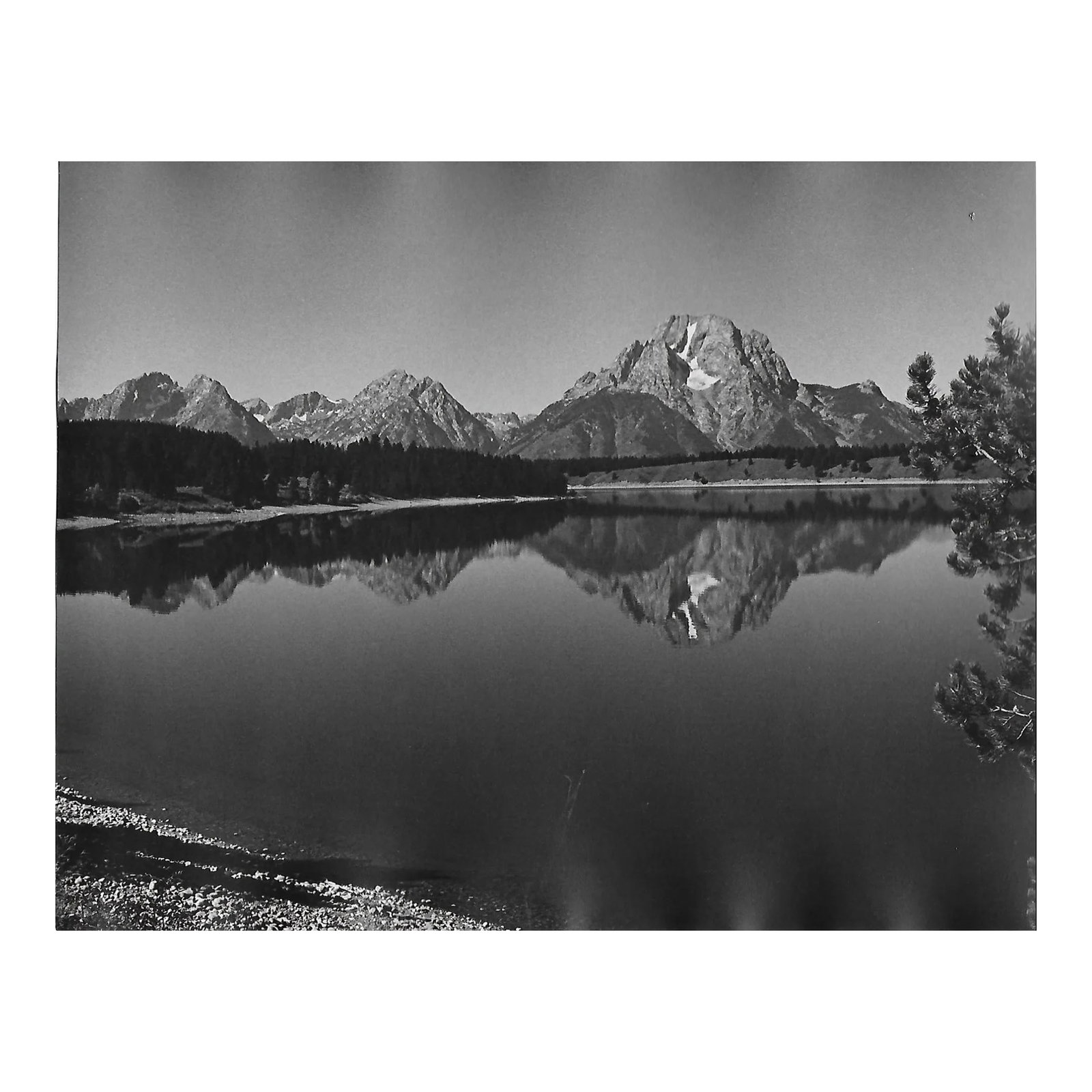 1975 Grand Teton Landscape Photograph by Don Ware: 1975 black and white photo by Don Coleman Ware (1921-2006) of a lake and mountain landscape in Grand Tetons National Park. Titled, Dated and bearing Ware's studio stamp on the back. Condition: Alterat