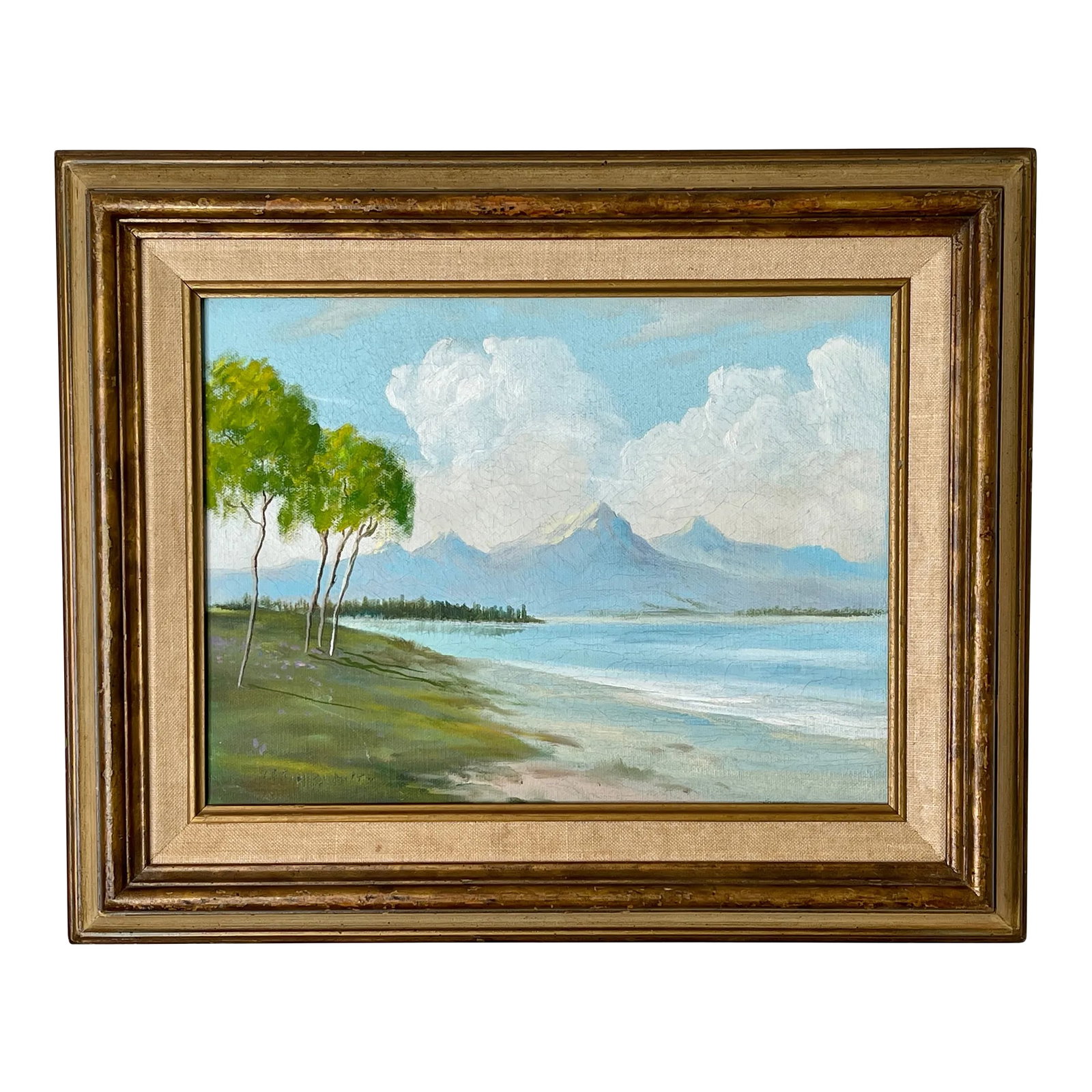 1971 South Seas Framed Oil Painting: A deserted beachscape with jagged mountain peaks in the distance. Voluminous clouds behind the mountains add a dreamlike quality. Signed somewhat illegibly, dated '71. Somewhere in the South Pacific..