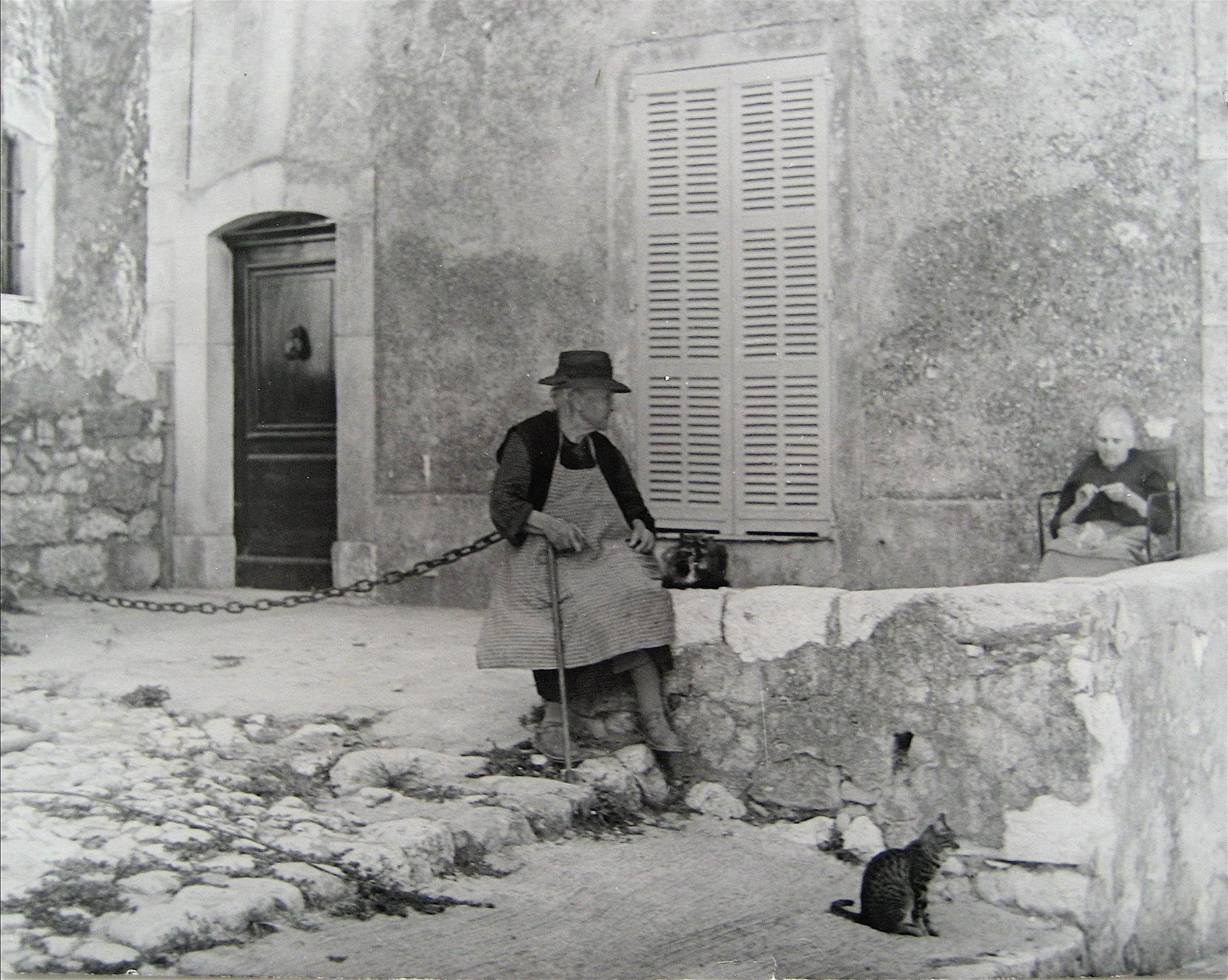 Cat on a Side Street European Scene 1960s Black and White Photograph: This 1960s black and white photograph European street scene is by New York/San Francisco photographer Roz Joseph (1926-2019). Joseph travelled extensively through Europe, North Africa, and Asia in