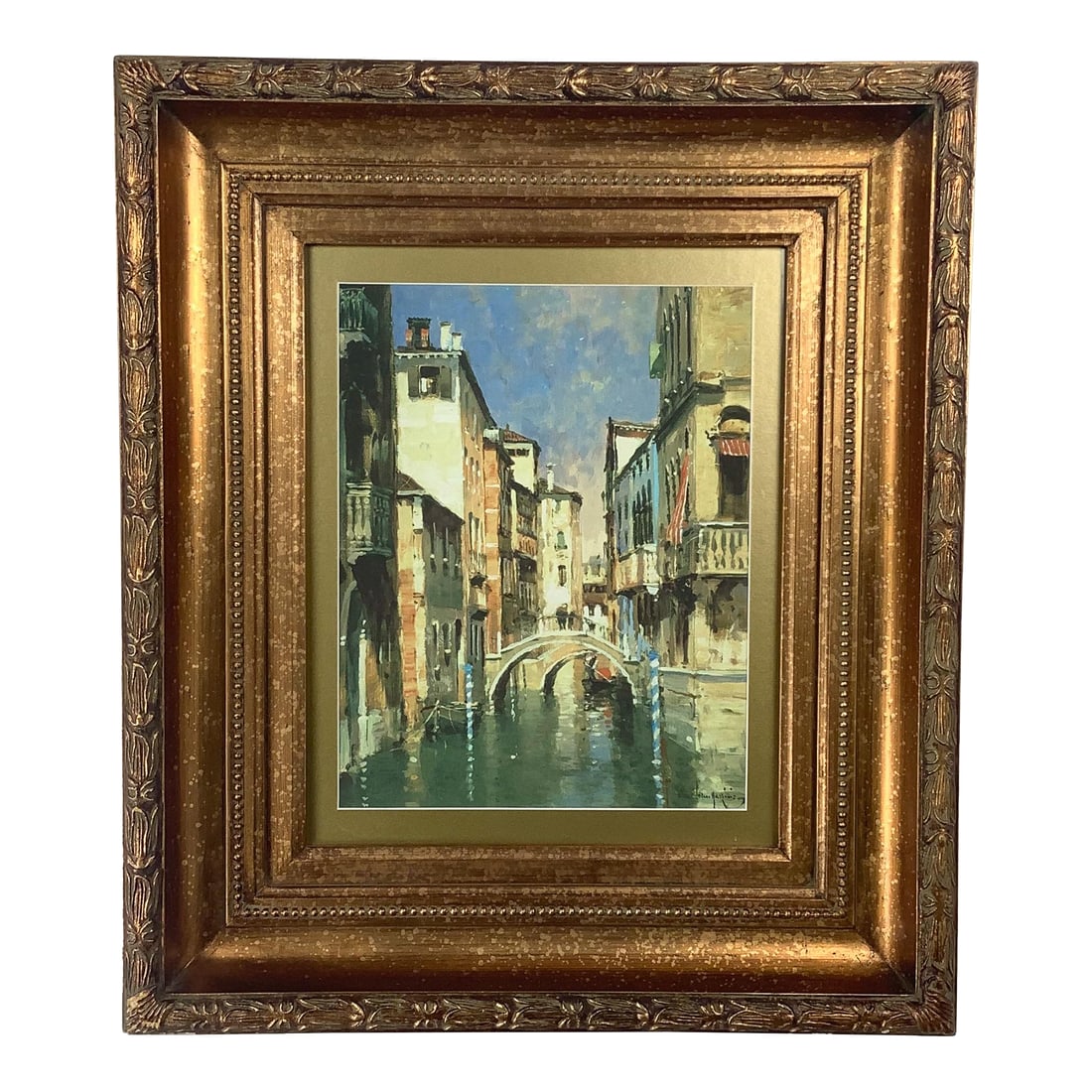 Vintage European Canal Scene in Ornate Gilt Wood Frame: This elegant framed artwork features a classic European canal scene, depicting tall historic facades, a graceful arched bridge, and softly reflected light along the water's surface. The composition