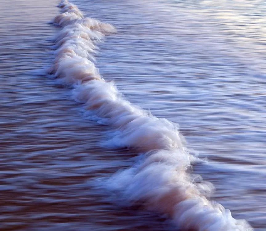 Evening Ghost Wave - Photograph by George Diebold - Plexiglas Laminated - Island of Kauai, Hawaii: EVENING GHOST WAVE - Kauai, Hawaii (C) George Diebold "On a small strip of sand, the impact of two waves causes a mysterious liquid shape to appear. If you recall your geography terms, it will help
