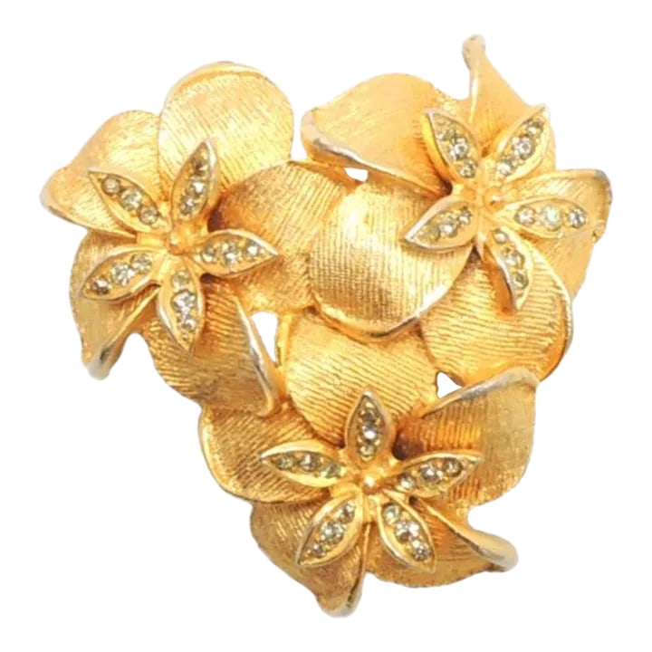 Vintage 1960s DeNicola 3 Flowers Rhinestone Brooch: This is part of Chairish's Costume Jewelry assortment. 1960s three goldtone textured flowers with small round clear rhinestone accents brooch with security clasp. Marked "DeNicola." Measures: 1 3/4