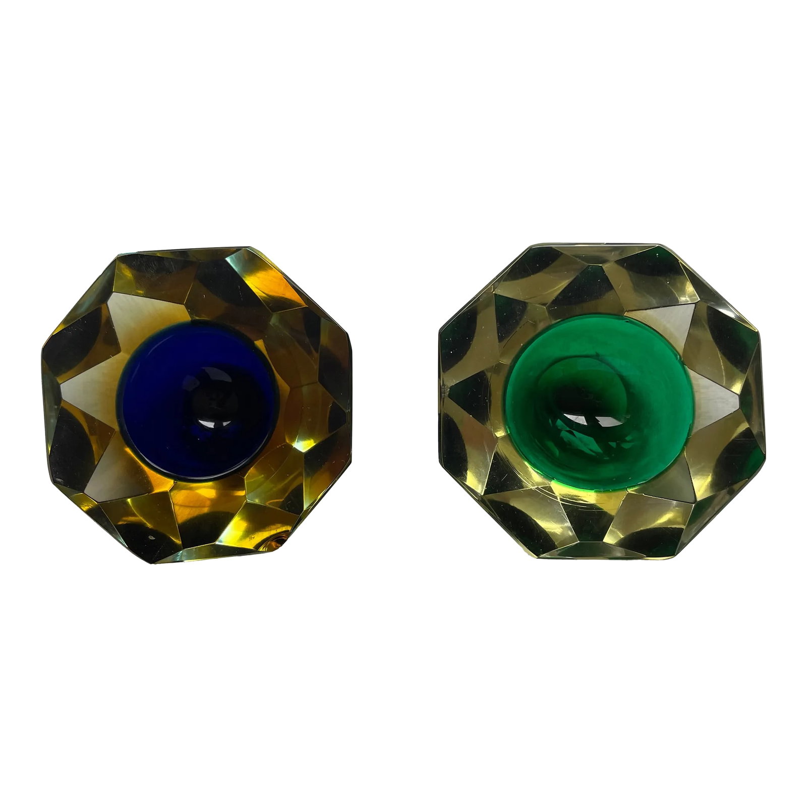 Pair of Murano Glass Geode Bowls: Beautiful pair of faceted geode bowls. One is green inside clear glass and the blue is surrounded by yellow and then clear. Both having facets make them look like late gem stones for your table